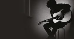 man playing guitar black and white