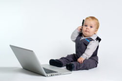 baby talking on phone with computer